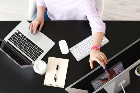 Female programmer working with laptop and computer in officeの写真素材