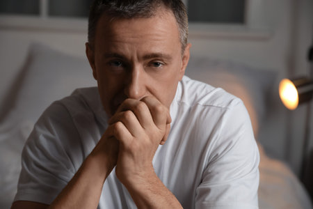 Depressed mature man in bedroomの写真素材