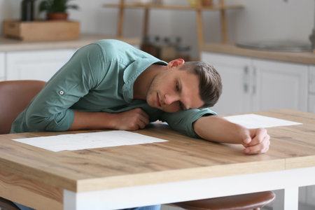Depressed young man at homeの写真素材