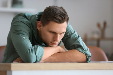 Depressed young man at homeの写真素材