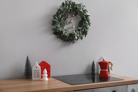 Christmas wreath hanging on gray wall in kitchenの写真素材
