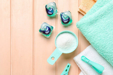Laundry detergents, clothes pins and towels on wooden backgroundの写真素材