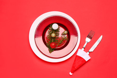 Stylish Christmas table setting with decor on red background