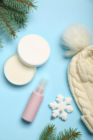 Composition with cosmetic products, warm hat and fir branches on color backgroundの写真素材