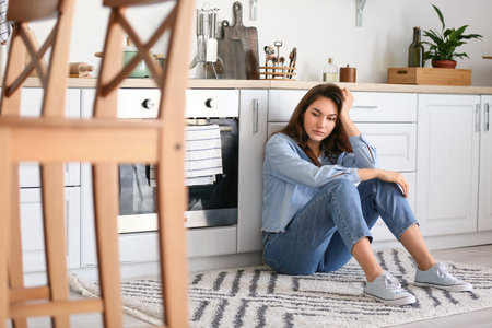 Depressed young woman at homeの写真素材