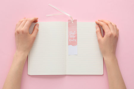 Woman with notebook and bookmark on color backgroundの写真素材