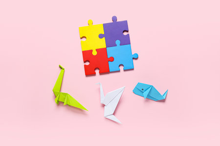 Colorful puzzle pieces and origami on color background. Concept of autistic disorderの写真素材