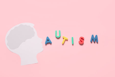 Paper human head with word AUTISM on color background. Concept of autistic disorder
