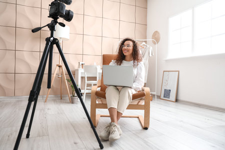 Young female clothes stylist recording video in studio