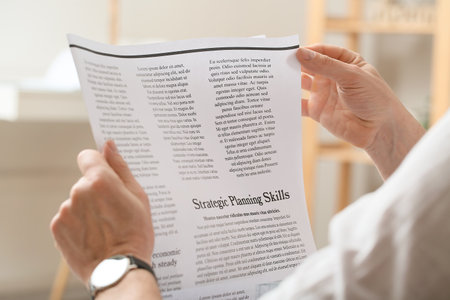Mature man reading newspaper at home, closeup
