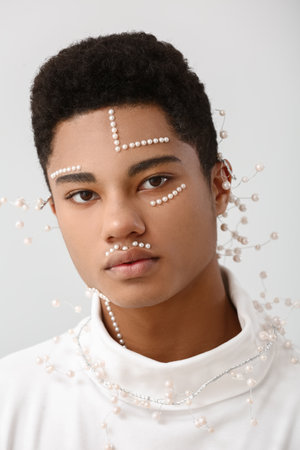 Creative portrait of handsome African-American guy on light background