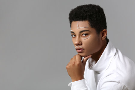 Creative portrait of handsome African-American guy on gray background