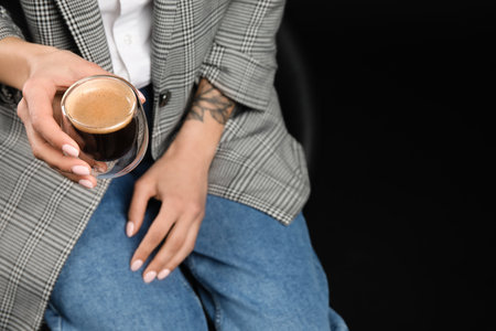 Woman drinking tasty coffee on dark background, closeupの写真素材