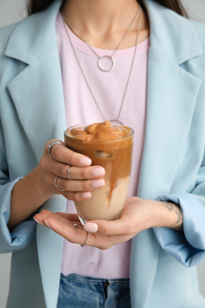 Woman drinking tasty coffee on gray background, closeupの写真素材