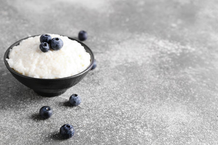 Bowl with delicious rice pudding and blueberry on gray tableの写真素材
