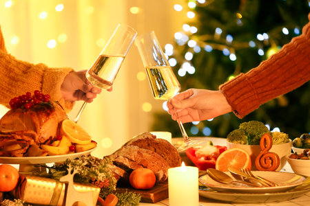 Women with glasses of champagne having Christmas dinner at nightの写真素材