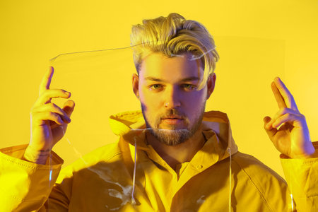Toned portrait of handsome young man with plastic on color backgroundの写真素材