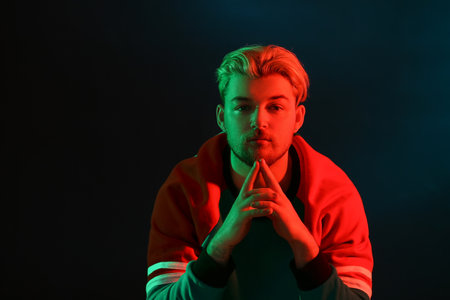 Toned portrait of handsome young man on dark background