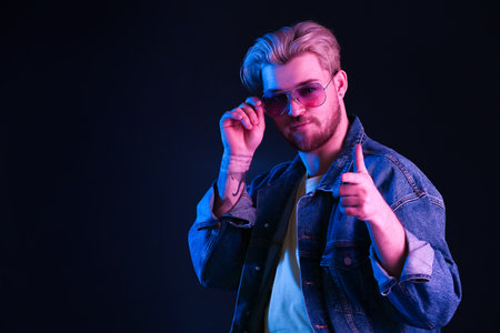 Toned portrait of handsome young man on dark background