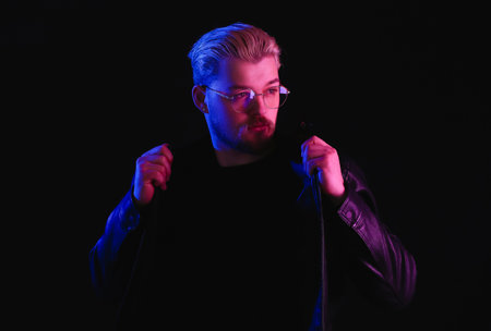 Toned portrait of handsome young man on dark background