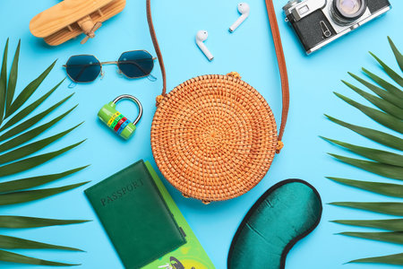 Composition with stylish bag, accessories, documents and palm leaves on color background
