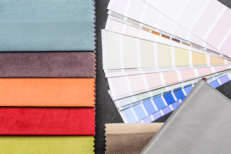 Composition with paint palette colors and fabric samples on dark background