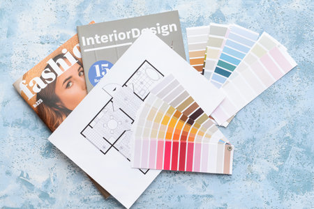 Paint color samples with house plan and magazines on color background