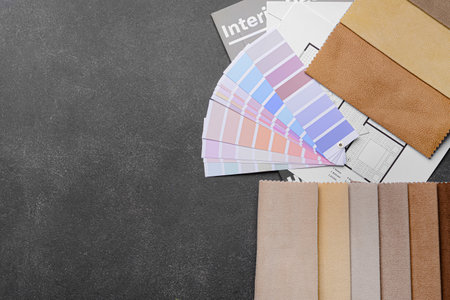 Composition with paint palette colors and fabric samples on dark background
