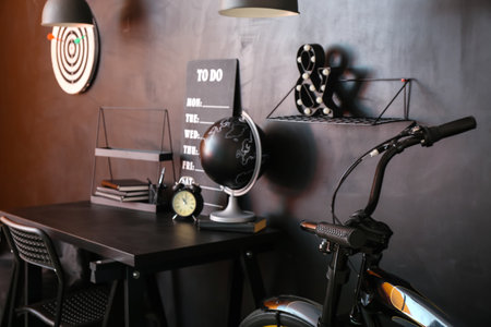 Interior of stylish room with modern workplace and bicycle