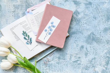 Book with bookmarks, notebook and flowers on color backgroundの写真素材