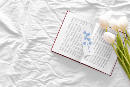 Book and beautiful flowers on bedの写真素材