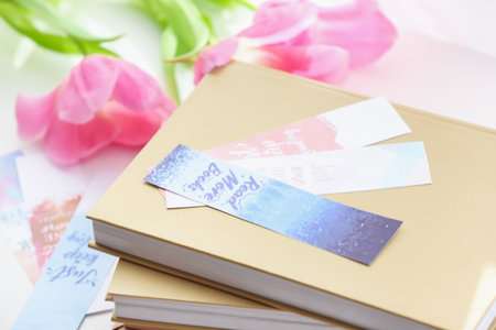 Books with bookmarks and flowers on light backgroundの写真素材
