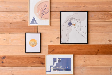 Stylish pictures hanging on wooden wallの写真素材