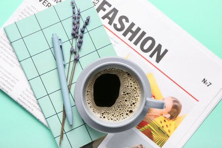 Composition with newspaper and cup of coffee on color backgroundの写真素材