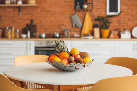 Basket with fresh fruits on dining table in modern kitchenの写真素材