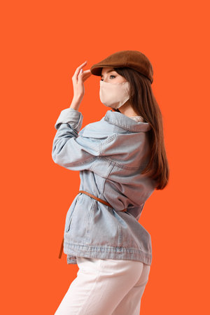Fashionable young woman wearing mask on color backgroundの写真素材