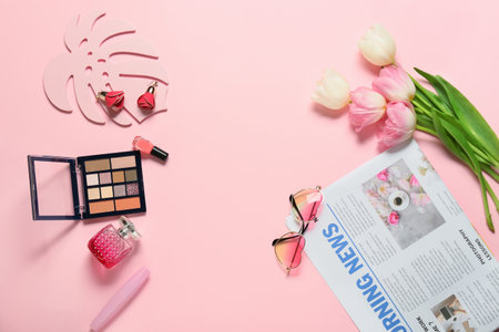 Stylish female accessories with flowers and newspaper on color backgroundの写真素材