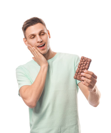 Surprised young man with tasty chocolate on white backgroundの写真素材