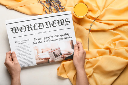 Woman reading newspaper on color fabric backgroundの写真素材
