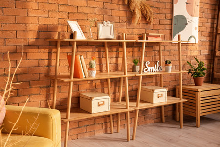 Books shelves with decor near brick wall