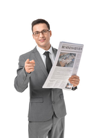 Young businessman with newspaper pointing at viewer on white backgroundの写真素材