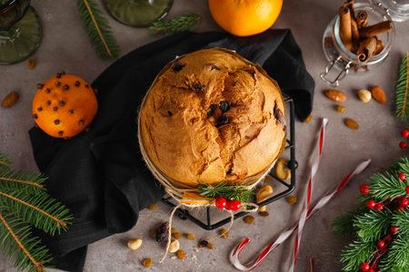Stand with tasty Panettone and Christmas decor on dark table, closeup