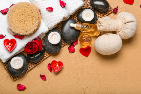 Spa composition for Valentine's Day with stones, rose petals and candles on beige backgroundの写真素材