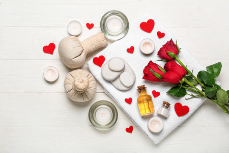 Spa composition for Valentine's Day with stones, roses and candles on white wooden backgroundの写真素材