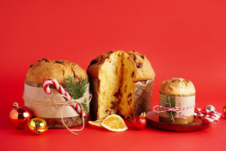 Tasty Panettones with Christmas decor on red backgroundの写真素材