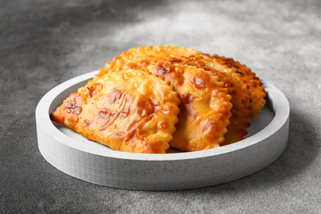 White plate with tasty chebureks on grunge background