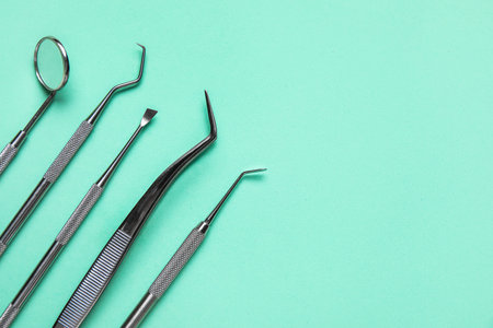 Dental tools on green background, closeup