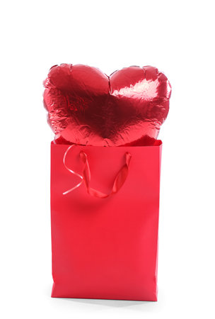 Shopping bag with heart-shaped balloon for Valentine's Day on white backgroundの写真素材
