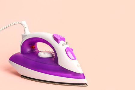 Electric iron on pink backgroundの写真素材