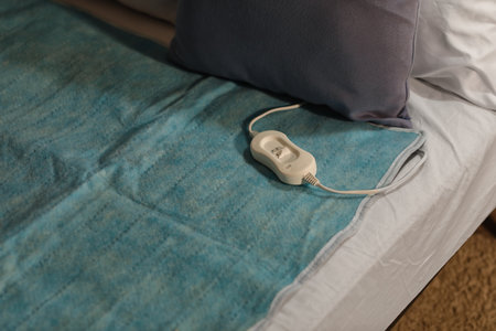 Electric heating pad with controller on bed at night, closeupの写真素材